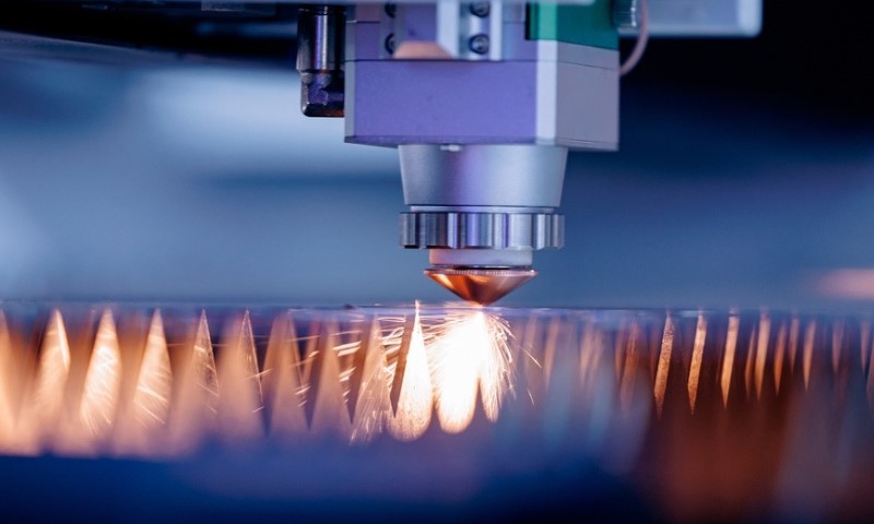 Close-up of a laser cutting machine emitting sparks as it precisely cuts through metal